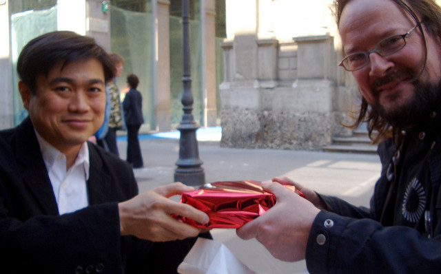 Personas intercambiando un regalo. El principio de reciprocidad es uno de los principios de influencia presentados en esta wiki. Intercambiarse un regalo nos obliga a devolver el favor. Fotografía de David Orban. Descargada desde: https://flic.kr/p/4BrPHD. Licencia CC BY 2.0